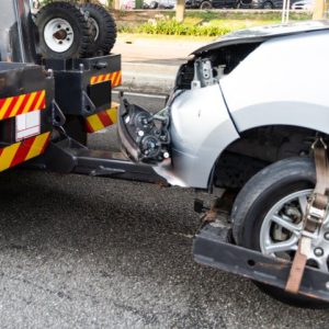 Tow truck towing broken down car from accident on road